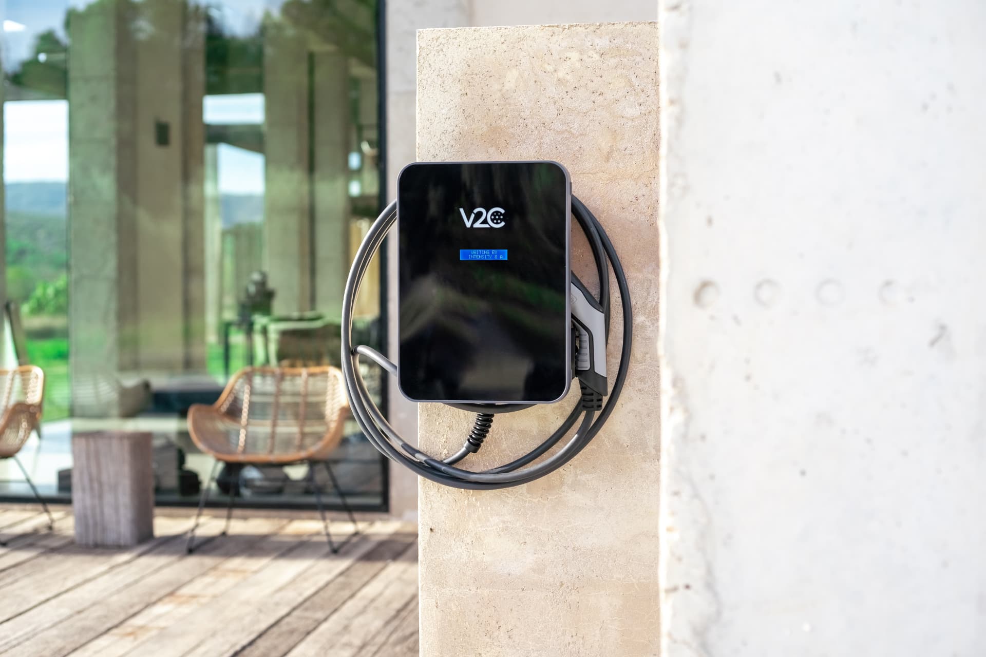 Cargador V2C Trydan instalado en el muro de una vivienda moderna